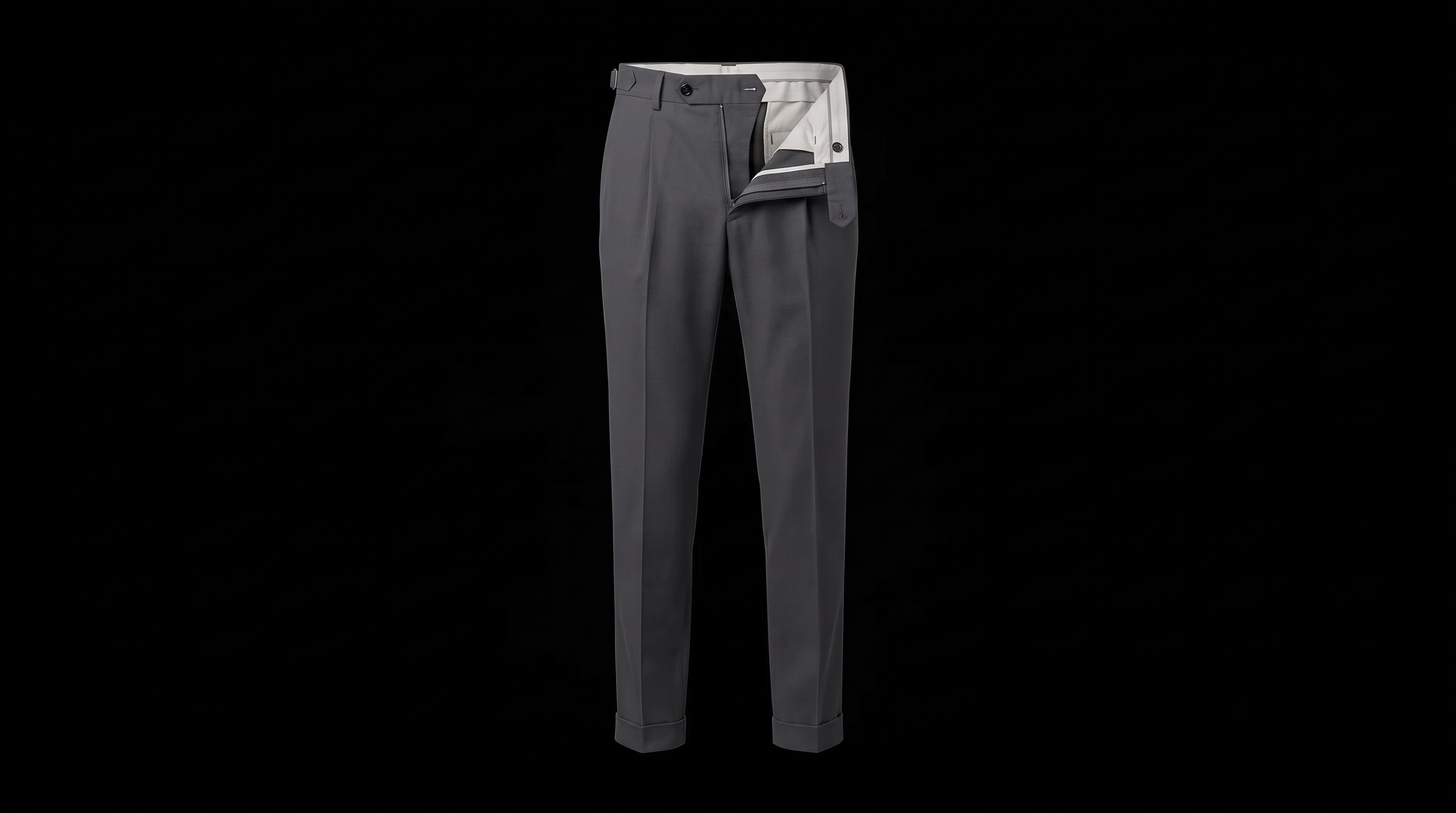 The charcoal trousers unfasten and the fly folds out, showing the ecru pocket bag and inner waistband